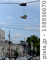 City Shoes Scene. Casual Sneakers Dangle Over Quiet Urban Neighborhood Under Clear Blue Sky 138936670