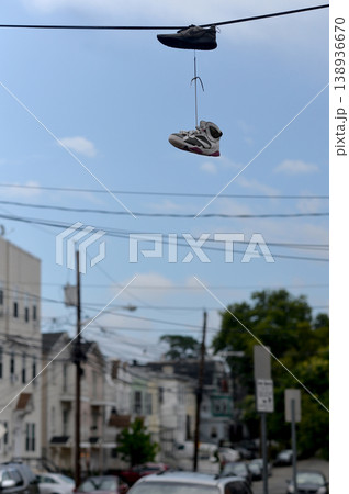 City Shoes Scene. Casual Sneakers Dangle Over Quiet Urban Neighborhood Under Clear Blue Sky 138936670