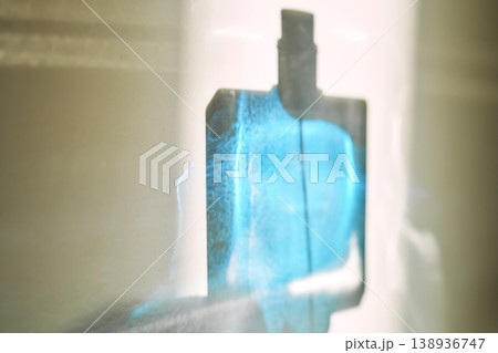 Perfume bottle silhouette glowing with blue liquid 138936747