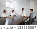 Three women engaged in business conversation at office table during daytime meeting. Conversation, table, business, meeting, women, office. 138936897