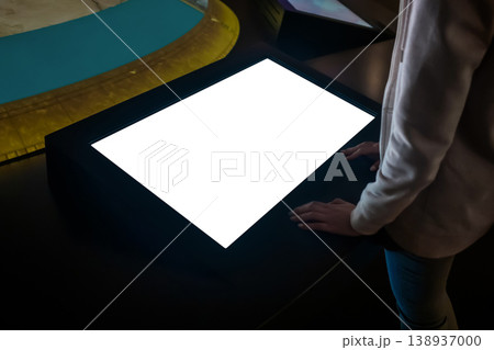 Woman using interactive empty white touchscreen display kiosk at exhibition Woman using interactive empty white touchscreen display kiosk at exhibition 138937000