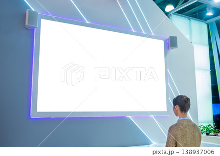 Woman looking at empty white large wall display at trade show - mockup image 138937006