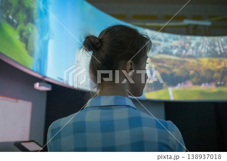 Young woman looking around in modern multimedia historical museum - back view Young woman looking around in modern multimedia historical museum - back view 138937018