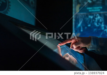 Woman using multimedia touchscreen display of interactive kiosk Woman using multimedia touchscreen display of interactive kiosk 138937024