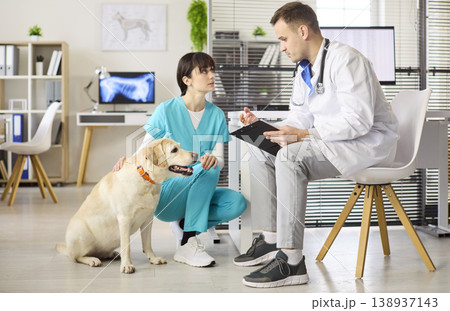 Veterinarian and nurse with labrador during checkup at modern pet clinic 138937143