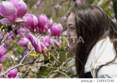 Woman enjoying cherry blossoms in a tranquil Japanese garden. Blossom delight. Woman enjoying cherry blossoms in a tranquil Japanese garden. Blossom delight. 138937248