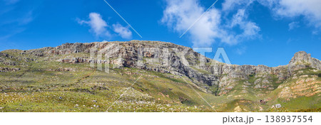 Widescreen landscape view of Table Mountain in Cape Town, South Africa. Low panoramic scenery of a popular natural landmark and tourist attraction during the day against a blue cloudy sky in summer 138937554