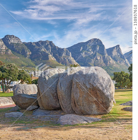 Landscape view of mountains beach rocks in famous travel or tourism destination with lush trees and grass. Scenic Twelve Apostles with blue sky and clouds in Camps Bay, Cape Town, South Africa Landscape view of mountains beach rocks in famous travel or tourism destination with lush trees and grass. Scenic Twelve Apostles with blue sky and clouds in Camps Bay, Cape Town, South Africa 138937618