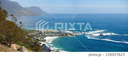 Panorama of a mountain coastline with quiet ocean against a blue sky in South Africa from above. Scenic wallpaper of a serene landscape of calm waves near Camps Bay with a peaceful sea view. Panorama of a mountain coastline with quiet ocean against a blue sky in South Africa from above. Scenic wallpaper of a serene landscape of calm waves near Camps Bay with a peaceful sea view. 138937623