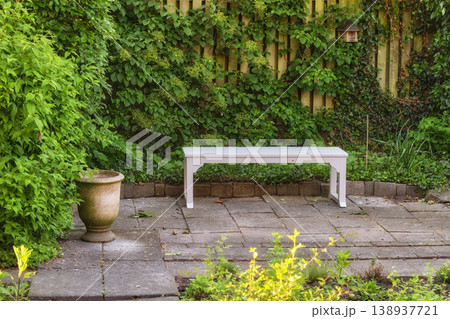 Gardeners corner. Private chair in green garden in the beautiful outdoors. A place with green nature views outside. Resting area for relaxation and isolated seating area surrounded by natural life. 138937721