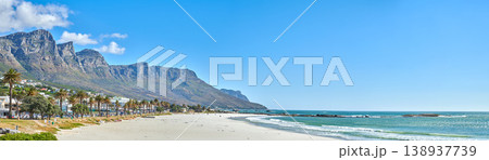 Quiet and calm beach and ocean with sandy shore and palm trees. Scenic seascape of the Twelve Apostles mountain under a blue sky in Cape Town. A beautiful holiday destination for travel and tourism Quiet and calm beach and ocean with sandy shore and palm trees. Scenic seascape of the Twelve Apostles mountain under a blue sky in Cape Town. A beautiful holiday destination for travel and tourism 138937739