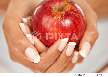 Hands, apple or food with a person closeup for health, diet or nutrition in the kitchen of her home. Fruit, nutritionist and hunger with an adult eating fresh produce for a healthy weight loss snack Hands, apple or food with a person closeup for health, diet or nutrition in the kitchen of her home. Fruit, nutritionist and hunger with an adult eating fresh produce for a healthy weight loss snack 138937900