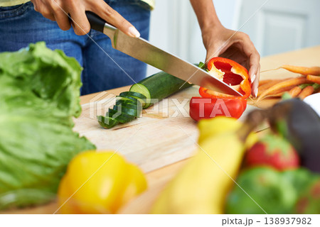 Woman, hands and cutting vegetables in kitchen on wooden board for healthy diet or vegetarian meal at home. Closeup of female person slicing natural organic red pepper for salad preparation at house Woman, hands and cutting vegetables in kitchen on wooden board for healthy diet or vegetarian meal at home. Closeup of female person slicing natural organic red pepper for salad preparation at house 138937982