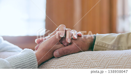 Comfort, support and senior couple holding hands in living room at modern home for romance and compassion. Love, empathy and closeup of elderly man and woman with affection in the lounge of a house. Comfort, support and senior couple holding hands in living room at modern home for romance and compassion. Love, empathy and closeup of elderly man and woman with affection in the lounge of a house. 138938047