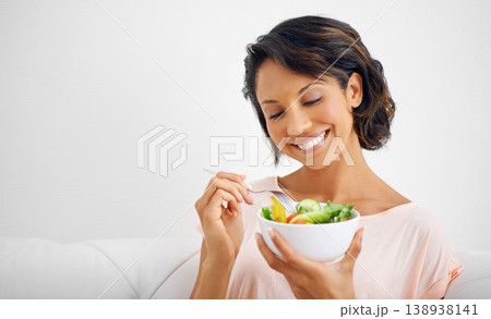 Happy woman, bowl and eating salad for healthy diet, natural nutrition or wellness on living room sofa at home. Female person, vegan or nutritionist smile for vegetarian meal, fiber or vitamin snack Happy woman, bowl and eating salad for healthy diet, natural nutrition or wellness on living room sofa at home. Female person, vegan or nutritionist smile for vegetarian meal, fiber or vitamin snack 138938141