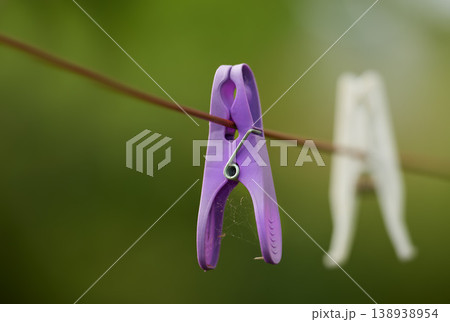 Clothespin. Closeup of neglected clothes pegs and housework, chores. Plastic clothespins hanging on washing cable or laundry line with bokeh and copy space outside. An abandoned hygiene routine. 138938954
