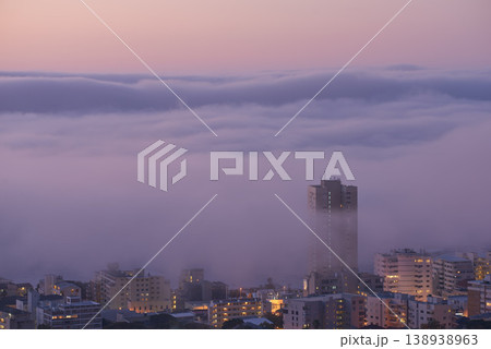Panoramic view of clouds covering buildings at sunset in the popular city of Cape Town, South Africa with copy space. A peaceful, misty sunrise over signal hill. Landscape of a modern town at night 138938963