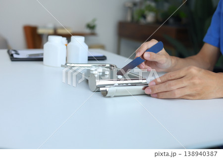 Healthcare Professional in Blue Scrubs Organizing Prescription Medication with Spatula and Pill Tray. Healthcare Professional in Blue Scrubs Organizing Prescription Medication with Spatula and Pill Tray. 138940387