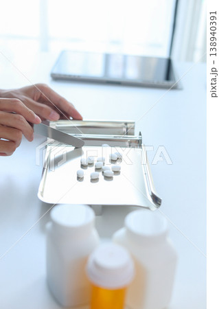 Healthcare Professional Organizing Prescription Medication with Spatula and Pill Tray. Healthcare Professional Organizing Prescription Medication with Spatula and Pill Tray. 138940391