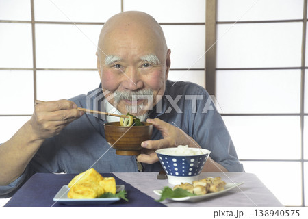 ご飯を笑顔で食べるヒゲの老人 138940575