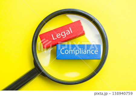 Legal Compliance text under magnifying glass representing legal and regulatory adherence. Legal Compliance text under magnifying glass representing legal and regulatory adherence. 138940759