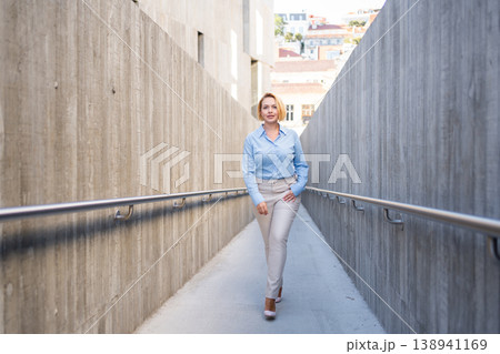 Confident businesswoman walking through modern 138941169