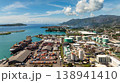 Large shipping containers and storage tanks located by the harbor, with green islands and turquoise waters in the background. Victoria. Seychelles, Mahe. 138941410