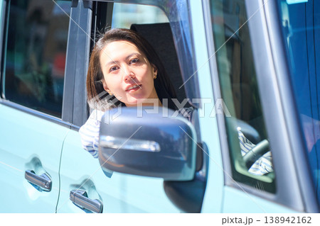 自動車の運転席で外を眺めて微笑む日本人女性 自動車の運転席で外を眺めて微笑む日本人女性 138942162