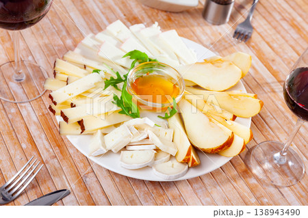 Cheese plate served with honey on wooden table 138943490