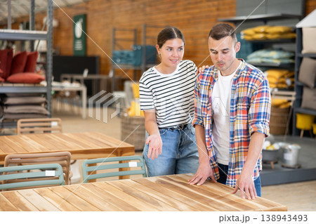Positive couple choosing patio table at garden store Positive couple choosing patio table at garden store 138943493