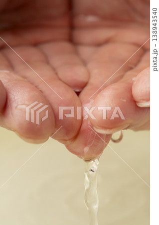 両手で洗面器の水をすくう 138943540