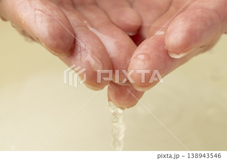 両手で洗面器の水をすくう 138943546