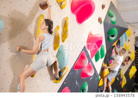 Young woman practicing rock climbing on climbing wall Young woman practicing rock climbing on climbing wall 138943578