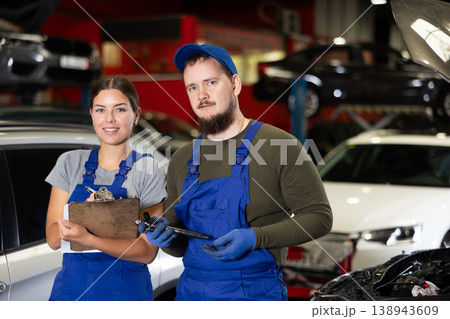 Guy and woman mechanics posing in car service 138943609