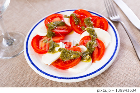 Caprese salad with mozzarella, tomatoes and pesto sauce on plate Caprese salad with mozzarella, tomatoes and pesto sauce on plate 138943634