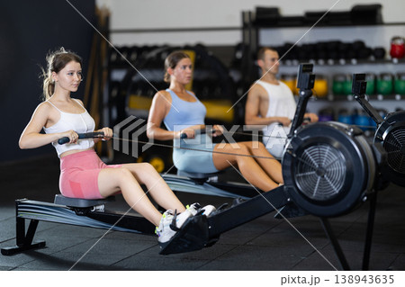 Young woman exercising on rowing machine Young woman exercising on rowing machine 138943635
