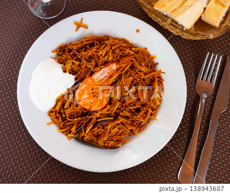Traditional spanish seafood dish fideua with aioli sauce in restaurant Traditional spanish seafood dish fideua with aioli sauce in restaurant 138943687