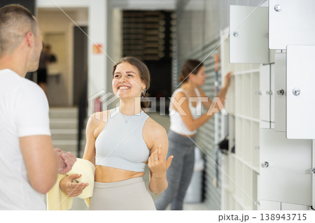 Young woman and man exchanged couple of phrases in locker room after changing clothes Young woman and man exchanged couple of phrases in locker room after changing clothes 138943715