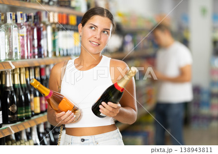 Young woman choosing champagne in store Young woman choosing champagne in store 138943811