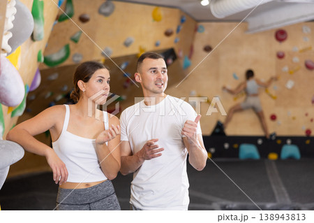 Coach instructing young female climber befor climb in bouldering gym Coach instructing young female climber befor climb in bouldering gym 138943813