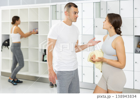 Young woman and man exchanged couple of phrases in locker room after changing clothes Young woman and man exchanged couple of phrases in locker room after changing clothes 138943834