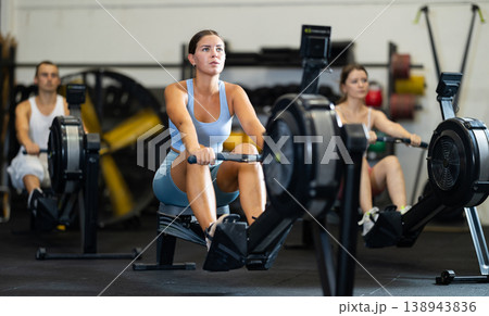 Young woman exercising on rowing machine Young woman exercising on rowing machine 138943836