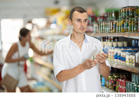 Male buyer chooses mayonnaise sauce in supermarket Male buyer chooses mayonnaise sauce in supermarket 138943888