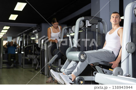 Man in sportswear trains his leg muscles on machine in the gym Man in sportswear trains his leg muscles on machine in the gym 138943944