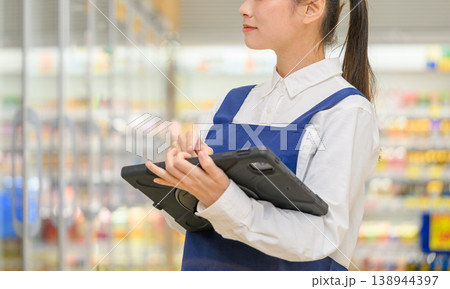 タブレットを操作する女性店員の顔のクローズアップ 138944397