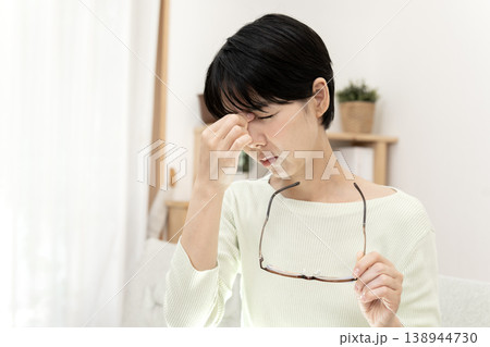 眼精疲労で目頭を押さえ、眼鏡を外して休息する日本人女性 138944730