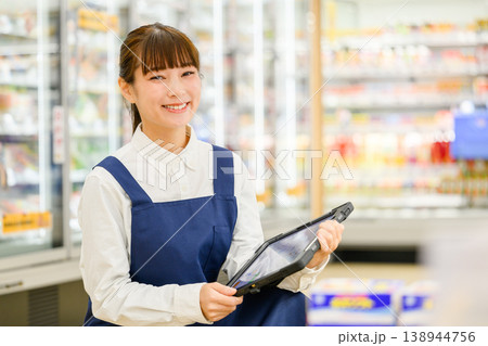 笑顔でタブレットを持つ女性店員 笑顔でタブレットを持つ女性店員 138944756