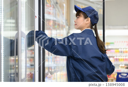 スーパー店員が冷蔵庫の商品をチェック スーパー店員が冷蔵庫の商品をチェック 138945008
