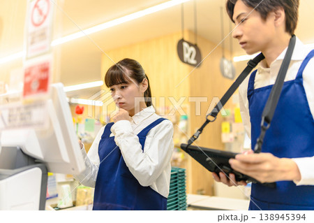 レジ操作を相談する店員 138945394