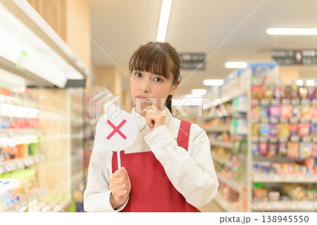 女性店員が✕サインで悩む 女性店員が✕サインで悩む 138945550